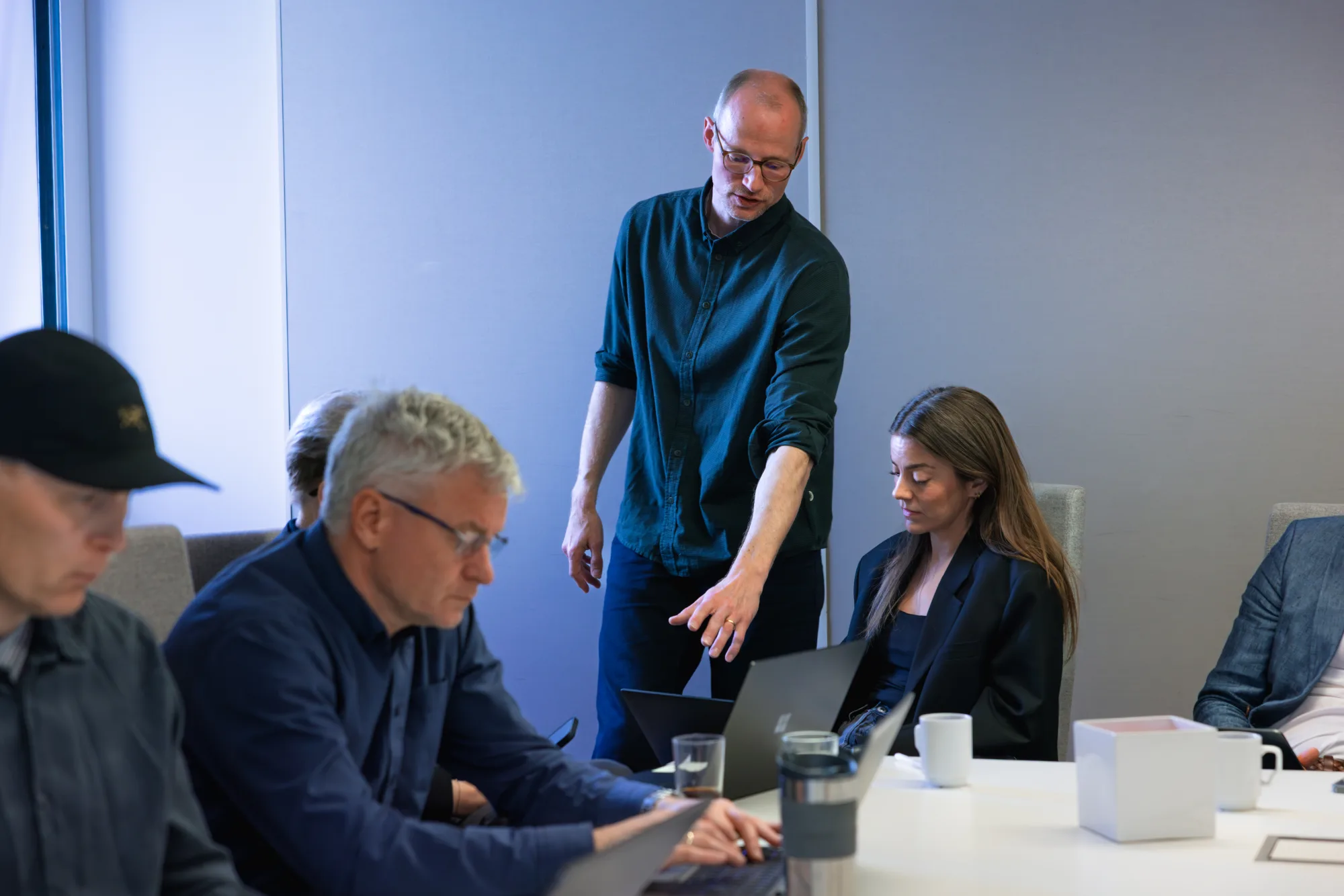 Trainer begeleidt een deelnemer achter de laptop